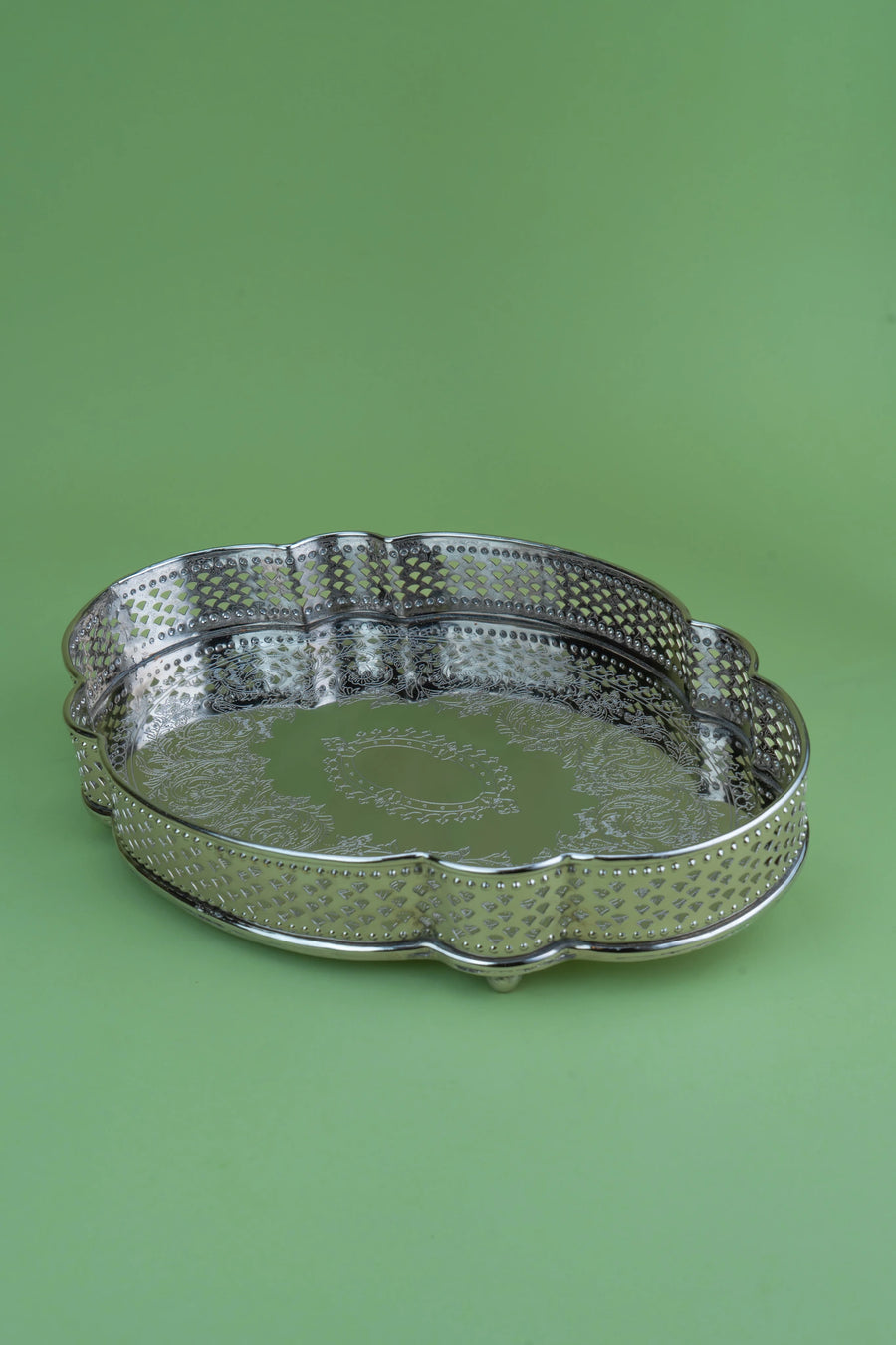 Scallop-edged German silver tray with intricate lattice jaal engraving on a dark background
